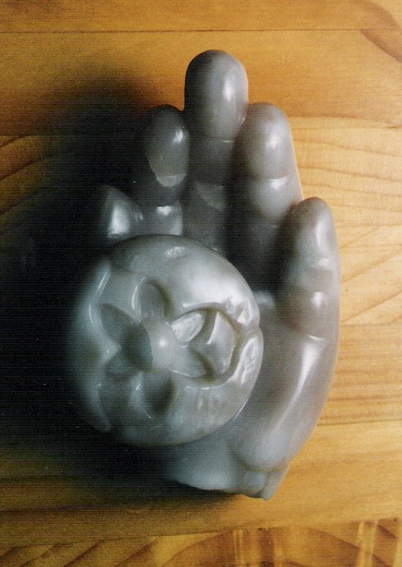 Een bloemknop in een kinderhand uitgewerkt in chinees speksteen